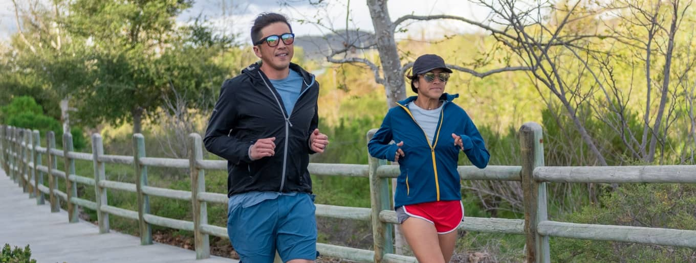 Two runners wearing running jackets from Nathan Sports.